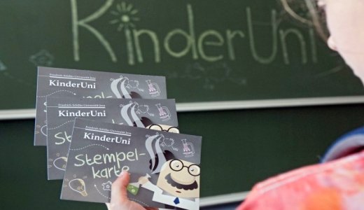 Kind mit KinderUNi Stempelkarte - Foto © FSU